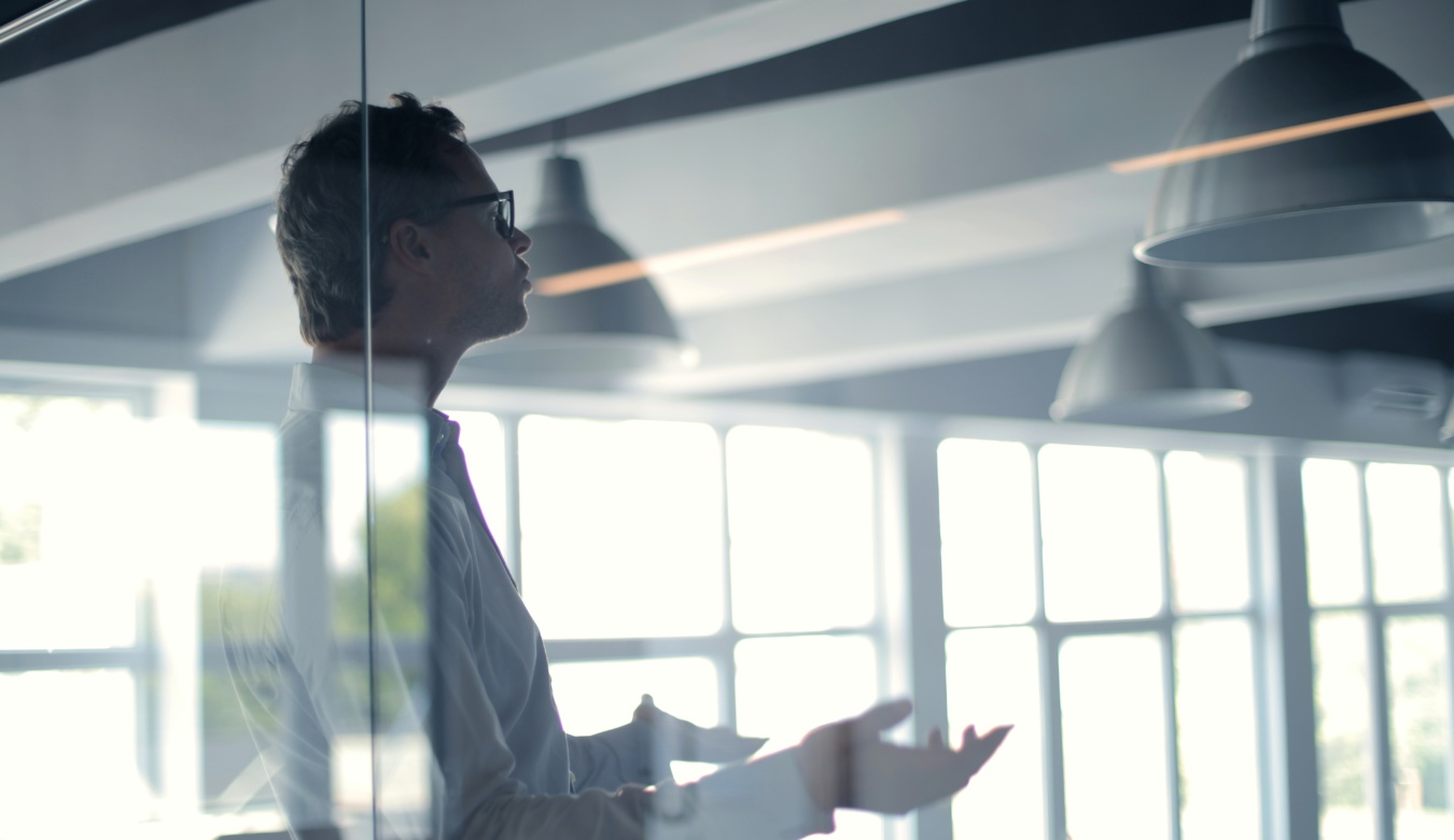 Man in boardroom gesticulating