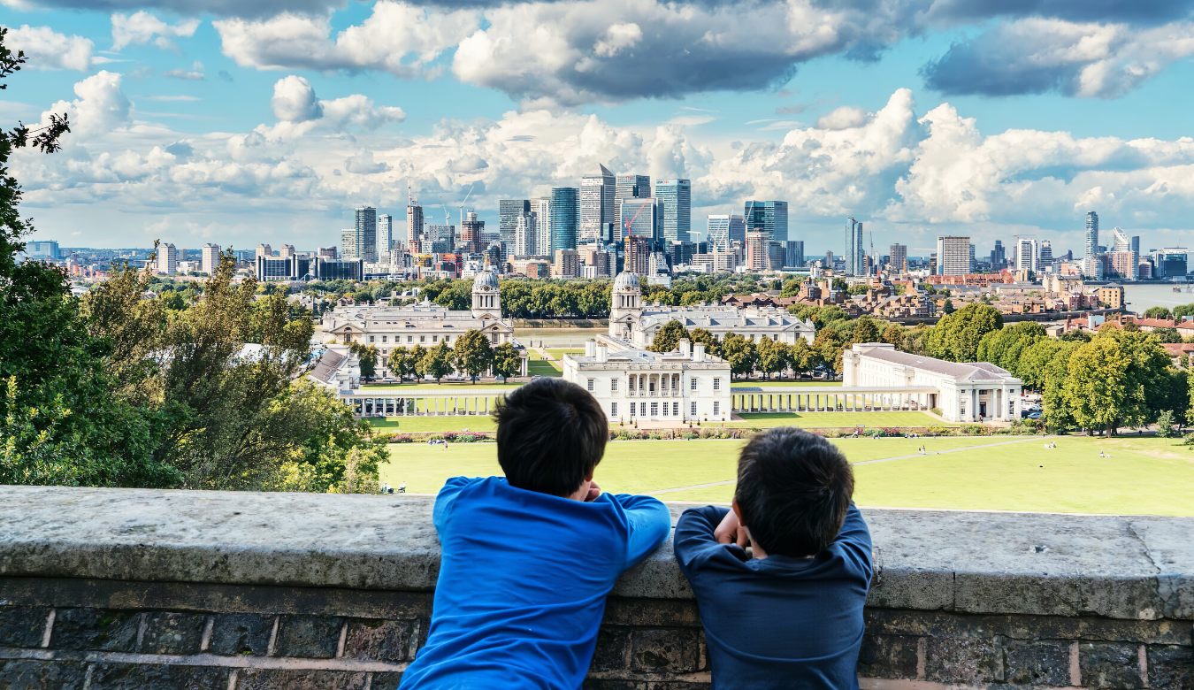 Two young boys looking over wall at view of London