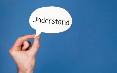 The word understand in a speech bubble on a blue background with a hand holding the speech bubble