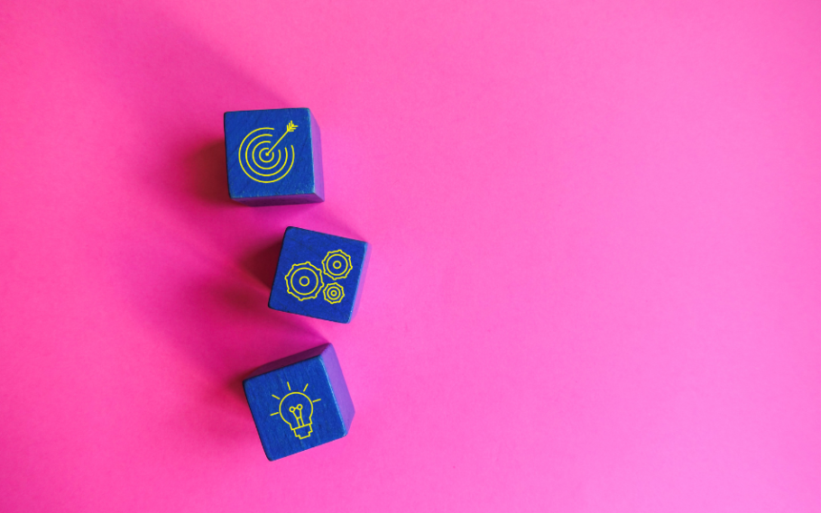 three blue dice with strategy icons on a pink background