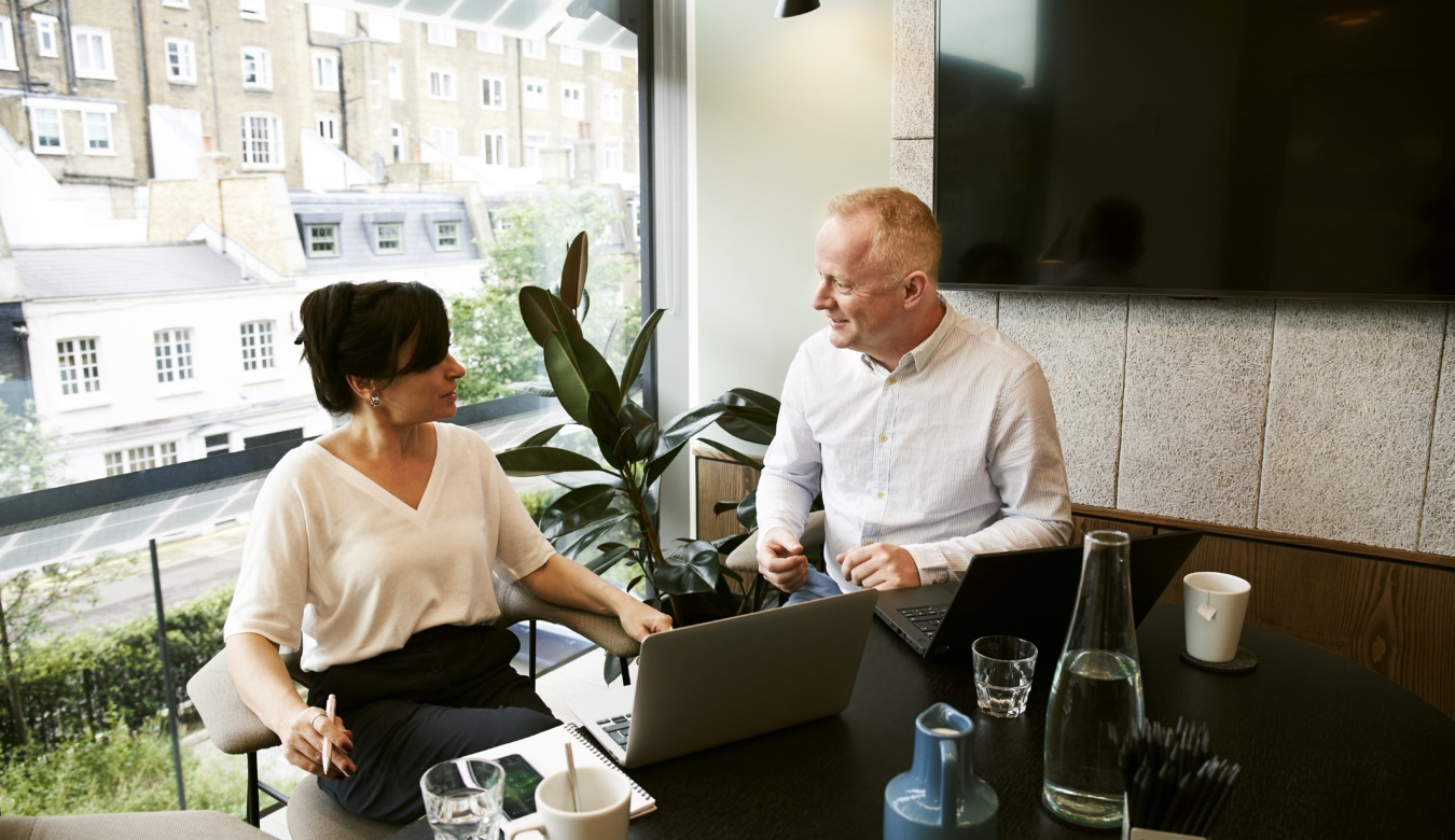 Business man and woman Discussing And Sharing Ideas in office with a view