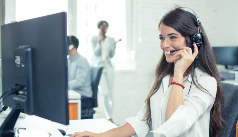 Female office worker smiling while on the phone wearing a headset