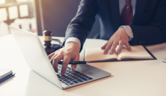 Close up of business man typing up notes onto laptop