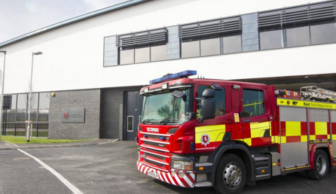 Red fire engine parked in front of kent fire and rescue service station